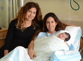 Las hermanas Moran y Shani Nahum en el hospital Rambam. Una de ellas tiene a su bebé en brazos mientras ella está  sentada en la cama, Su hermana está a su lado,