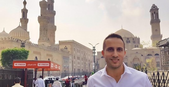 Yonatan Gonen, de camisa blanca, de fondo la calle, transeúnes, hermosos edificios