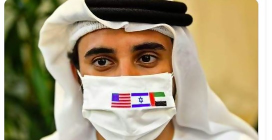 Un emiratí con vestimenta tradicional, con un tapabocas con las banderas de Israel, los Emiratos Arabes Unidos y Estados Unidos