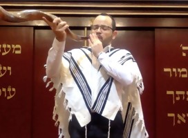 El Rabino Godet, cubierto con el talit, tocando el Shofar