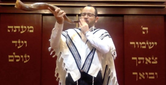 El Rabino Godet, cubierto con el talit, tocando el Shofar