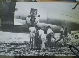 Una avioneta en tierra, gente agolpada junto a la puerta