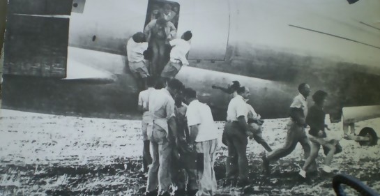 Una avioneta en tierra, gente agolpada junto a la puerta