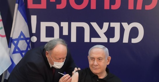 Netanyahu vacunándose. De fondo un cartel  vacuándose se gana